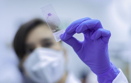 Purple-gloved hand holding a bio sample