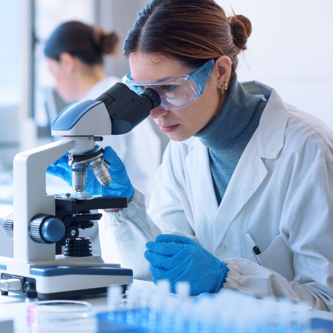 Scientist looking into a microscope in a lab
