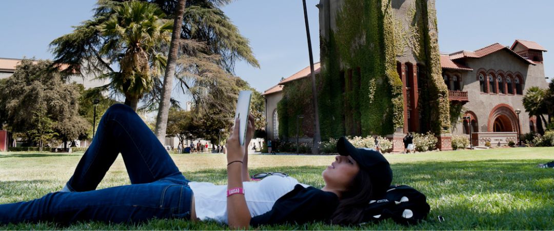 SFSU student lying on the grass at San Jose State University. 