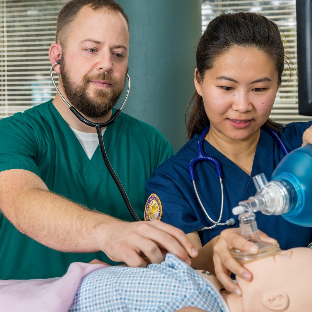 Two nurse practitioner students work on dummy patient