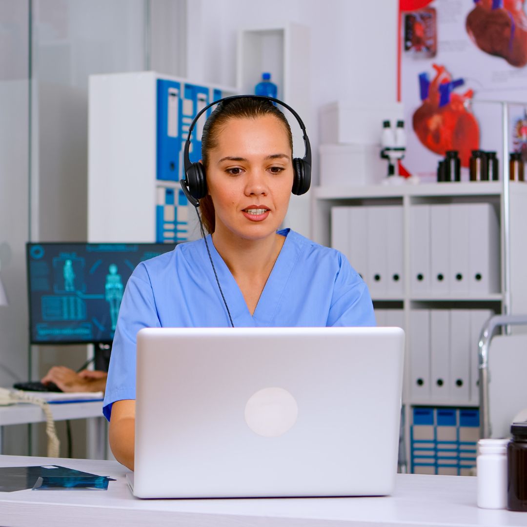 Medical Administrative Assistant works online while wearing headphones