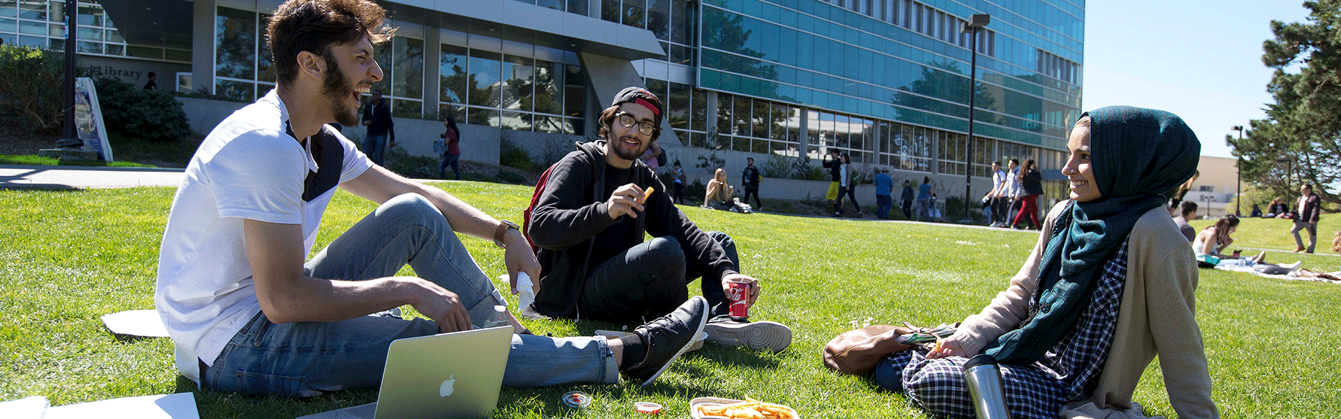Three students talking on the lawn