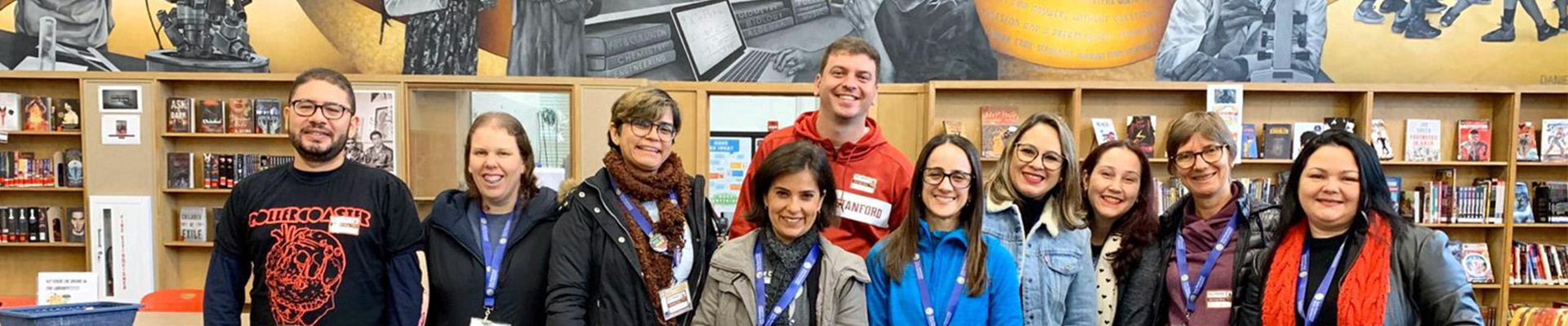Teacher trainees in the library, in front of a mural