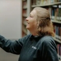 SFSU librarian looking at books in the stacks