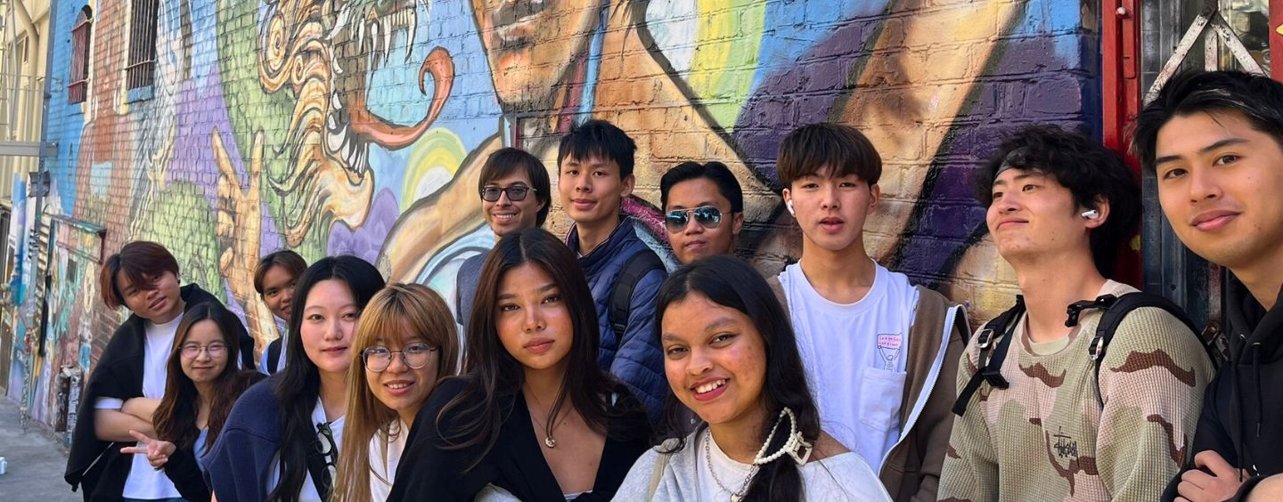 International student sin front of a Jackie Chan dragon mural in Chinatown