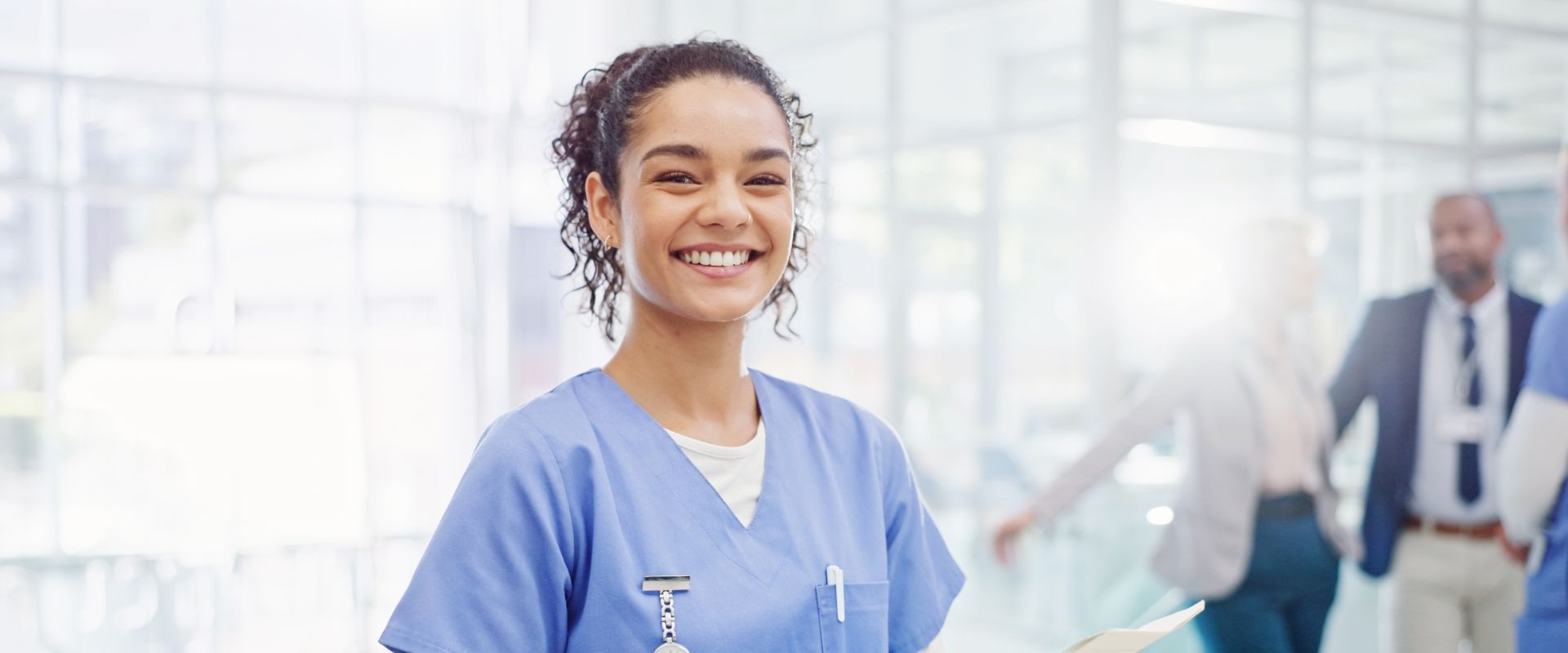 Clinical Medical Assistant smiles in a hospital hallway