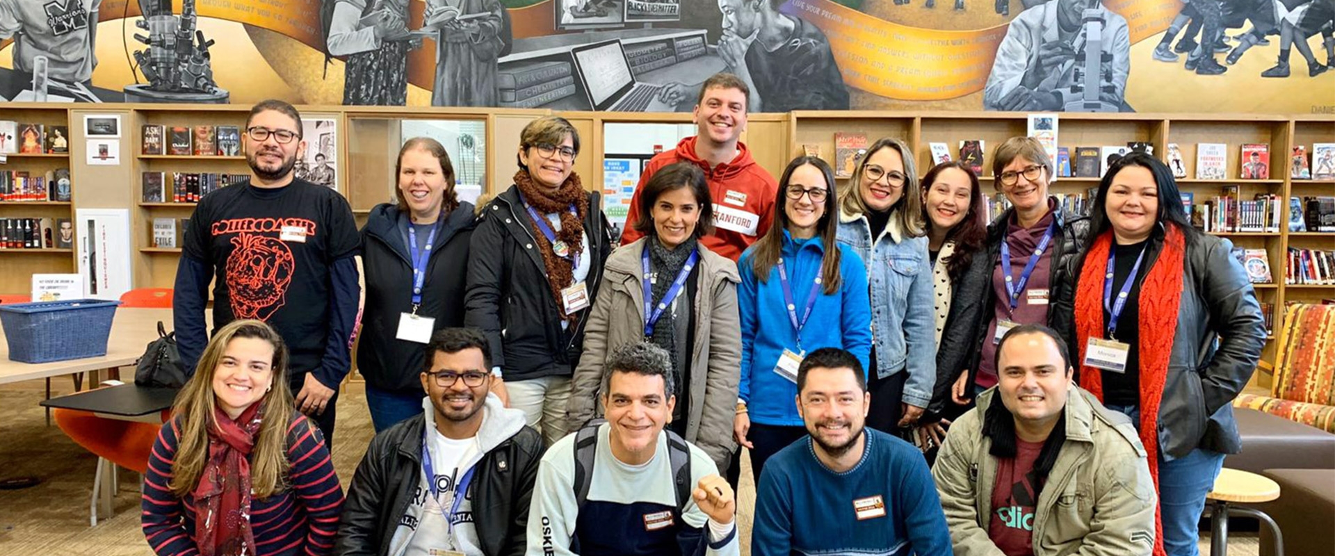 Teacher trainees in the library, in front of a mural