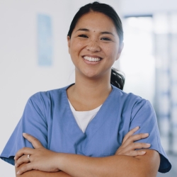 Surgical tech in scrubs, with sunlight behind her