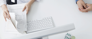 Medical Administrative Assistant with paperwork and computer