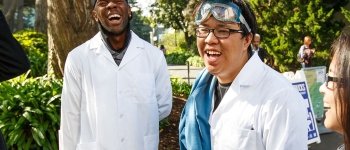 Pre-med students wearing lab coats and chatting on campus