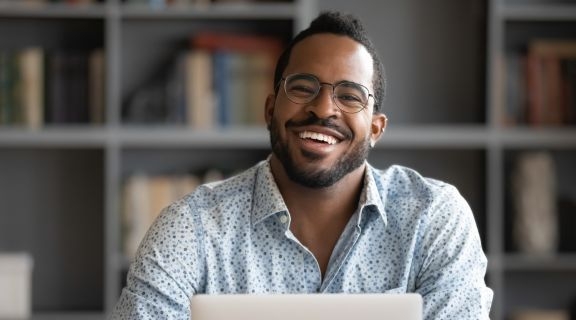 Man smiling while taking an online class